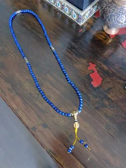 Lapis Lazuli mala displayed on a wooden table