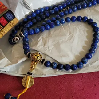 Lapis Lazuli mala resting on a textured surface