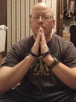 Verified customer in a prayer pose wearing his Lapis Lazuli mala